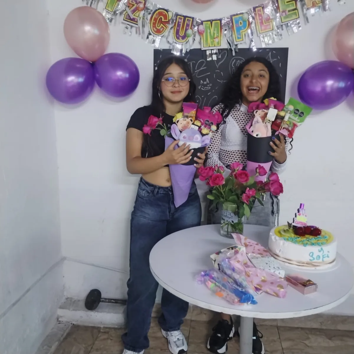 Mafe y Sofi celebrando un cumpleaños con globos y flores